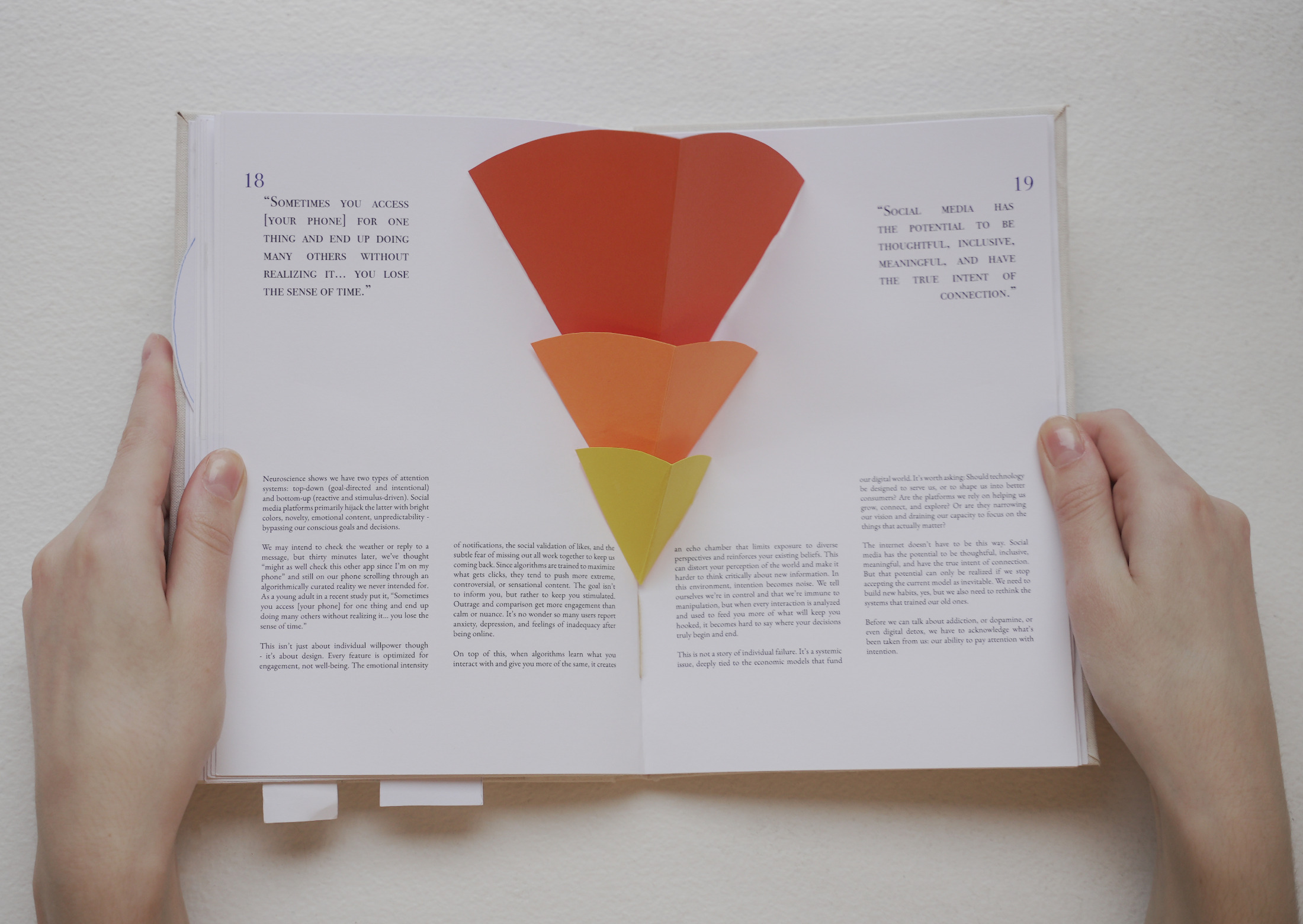 The For Stillness pop-up book held open to a layered orange funnel pop-up spread